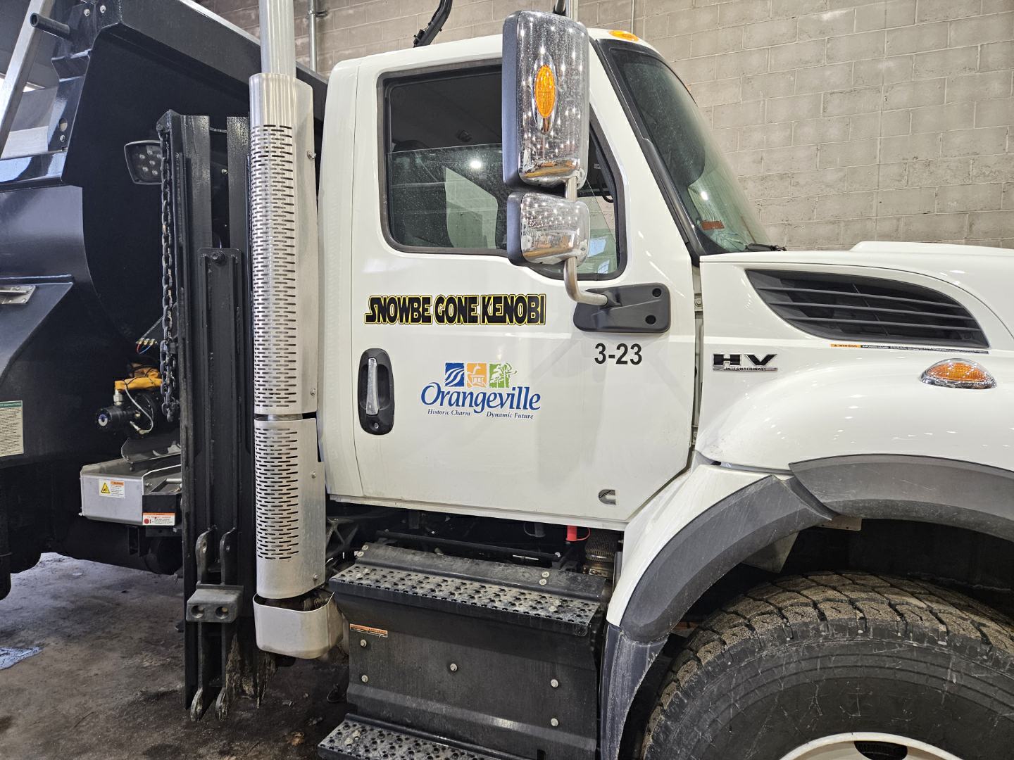 The side of a snowplow with a decal graphic on it